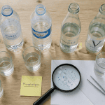 microplastique bouteille d eau sur table avec loupe et verres