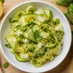 Courgette concombre crus en émulsion citron-huile sur planche bois